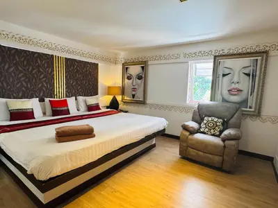 a bedroom with a large bed and a chair at Baipho Lifestyle in Patong Beach