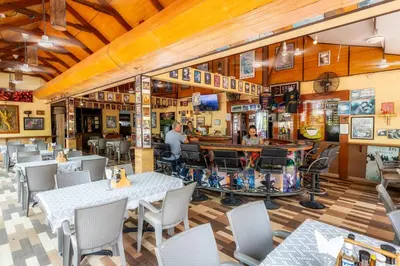 a restaurant with tables and chairs and a bar at The Expat Hotel Patong in Patong Beach