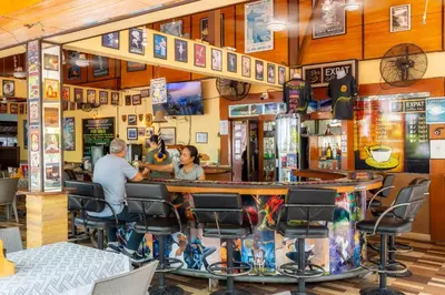 a man and woman sitting at a bar in a restaurant at The Expat Hotel Patong in Patong Beach