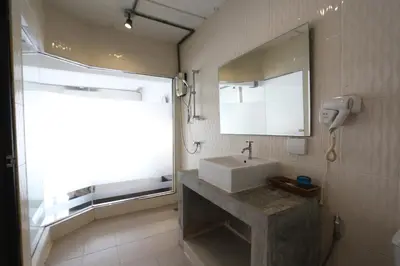 a bathroom with a sink and a mirror and a window at The Nest Resort Patong in Patong Beach