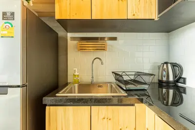 a kitchen with a stainless steel sink and wooden cabinets at Relife Windy by Holy Cow, courtyard view in Nai Harn Beach