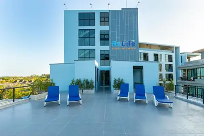 a group of blue chairs sitting on a building at Relife Windy by Holy Cow, courtyard view in Nai Harn Beach