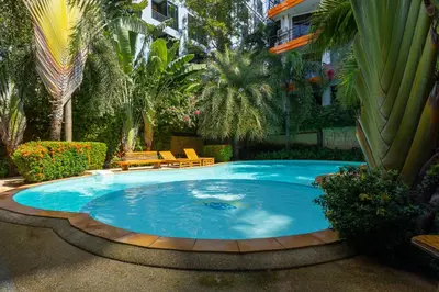 a large swimming pool in a yard with trees at NaiHarn Sea Condo, Top floor, Mountain View in Nai Harn Beach