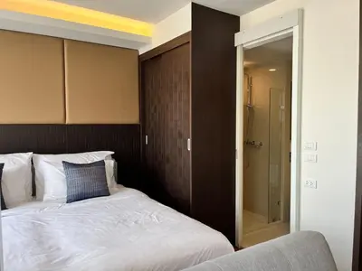 a bedroom with a bed and a walk in shower at Aristo Resort Surin Beach K5 in Phuket Town