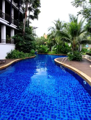 a large blue swimming pool next to a building at Kata gardens 2 bedroom near Kata beach 3B in Kata Beach