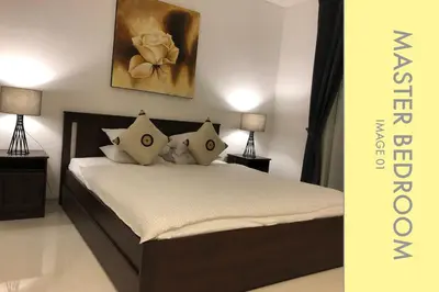 a bedroom with a bed with two lamps and a painting at Stylish Condo Stunning Views in Kamala Beach