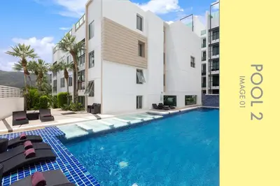 a swimming pool in front of a building at Stylish Condo Stunning Views in Kamala Beach