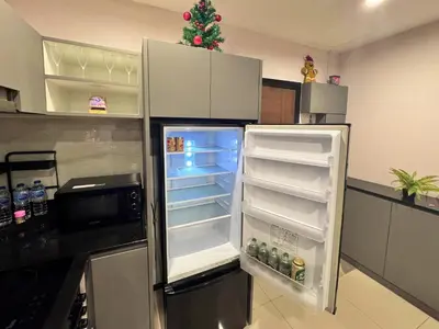 a kitchen with an open refrigerator with a christmas tree at NBC Condo, 2-BR, NaiHarn Beach in Nai Harn Beach