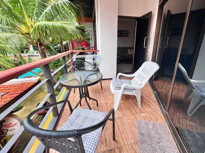 a balcony with chairs and a table and chairs at NBC Condo, 2-BR, NaiHarn Beach in Nai Harn Beach