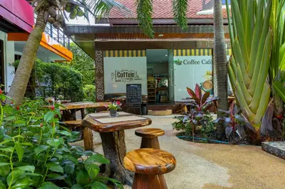 a store with a table and stools in a garden at NaiHarn Pearl Condo - Pets Friendly! in Nai Harn Beach