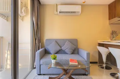 a living room with a couch and a table at NaiHarn Pearl condo by Holy Cow, 1-BR, courtyard view in Nai Harn Beach