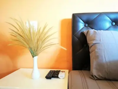 a vase with a plant on a table next to a bed at Phurafa Resort in Phang-nga