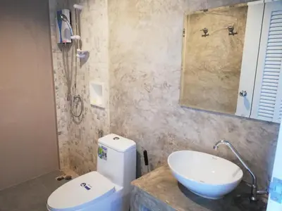 a bathroom with a white toilet and a sink at Laemsai Resort in Thalang