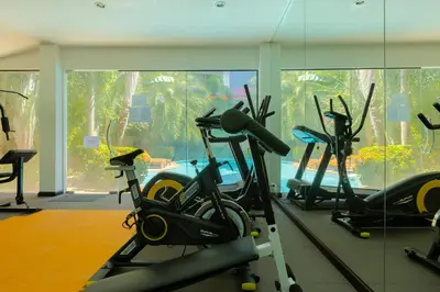 a gym with several exercise bikes in a room at NaiHarn Sea Condo by Holy Cow, 1-BR, courtyard view in Nai Harn Beach