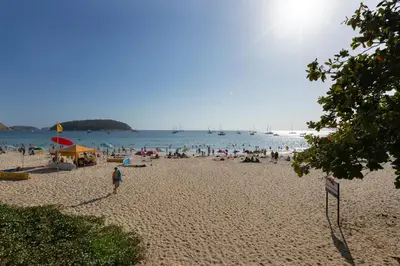 a group of people on a beach with the water at NaiHarn Sea Condo by Holy Cow, 1-BR, courtyard view in Nai Harn Beach