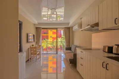 a kitchen and living room with a couch and a table at NaiHarn Sea Condo by Holy Cow, 1-BR, courtyard view in Nai Harn Beach