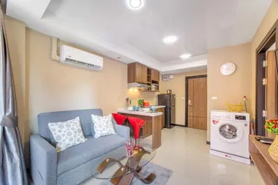 a living room with a blue couch and a kitchen at SOLA Condo 1BR Tropical View NBC Nai Harn Nai in Rawai Beach