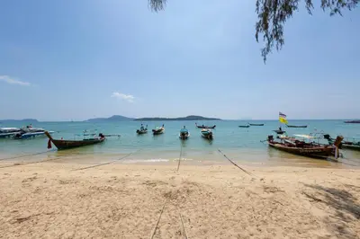 a group of boats in the water on a beach at Relife Windy by Holy Cow, studio with podium in Nai Harn Beach