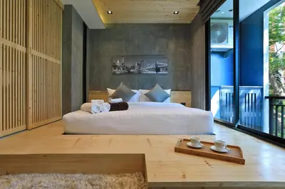 a bedroom with a large bed and a large window at Relife Windy by Holy Cow, studio with podium in Nai Harn Beach