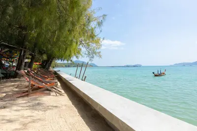 a couple of chairs sitting next to the water at Relife Windy by Holy Cow, country view in Rawai Beach