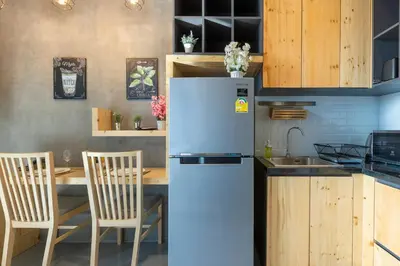 a kitchen with a refrigerator and a table with chairs at Relife Windy by Holy Cow, country view in Rawai Beach
