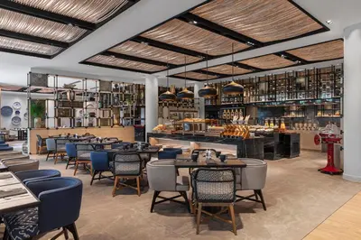 a restaurant with tables and chairs and a bar at Four Points by Sheraton Phuket Patong Beach Resort in Patong Beach