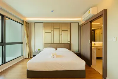 a bedroom with a large white bed and a large window at Sea View Panora Surin by Holy Cow, 1-BR in Surin Beach
