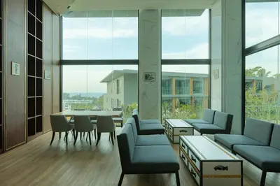 a room with chairs and tables and large windows at Panora Surin by Holy Cow, 1-BR, mountain view in Surin Beach