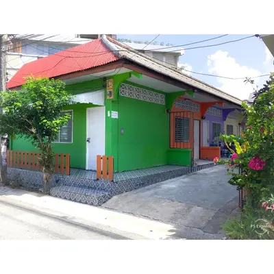 a green house with a red roof on a street at Phuket Town Budget House - Aircon Room #1 in Ban Lo Long