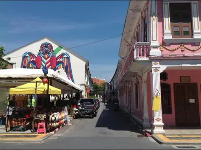 a street with a building with a colorful mural on it at Phuket Town Budget House - Aircon Room #1 in Ban Lo Long