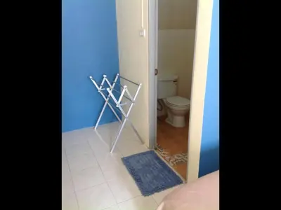 a bathroom with a toilet and a blue wall at Phuket Town Budget House - Aircon Room #1 in Ban Lo Long