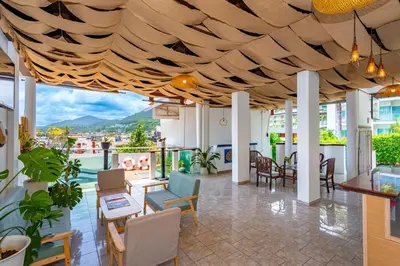a lobby with tables and chairs and a view at Kata Hill Sea View Hotel in Kata Beach