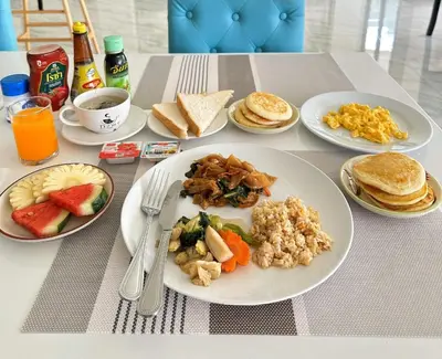 a table with plates of breakfast food on it at Dome Kata Resort in Kata Beach