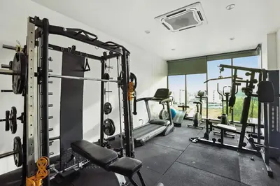 a gym with several tread machines in a room at Dome Kata Resort in Kata Beach