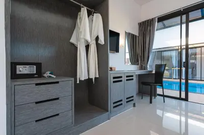 a bathroom with a vanity and a desk with a chair at Thames Tara Private Pool Villa Rawai Phuket in Rawai Beach