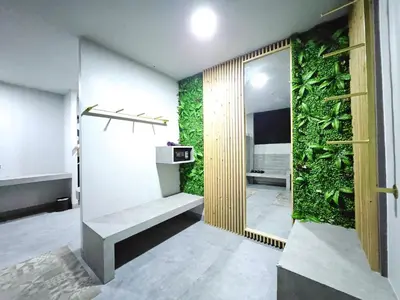 a bathroom with a green wall with a bench at Little Loft Hotel in Phuket Town