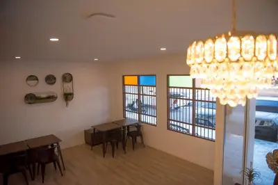 a dining room with a table and a chandelier at Mystays Phuket in Phuket Town