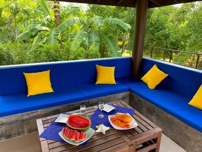 a table with two plates of fruit on a blue bench at Villa Tango Victoria Resort, Koh Yao Noi in Ko Yao Noi
