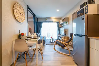 a kitchen and dining room with a table and a refrigerator at The Title Residencies Naiyang Beach in Nai Yang Beach