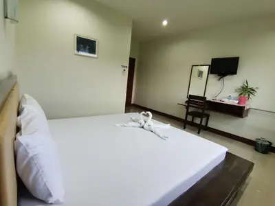 a bedroom with a large white bed and a desk at Nestvilla Khok-kloi Phang-nga in Ban Nai