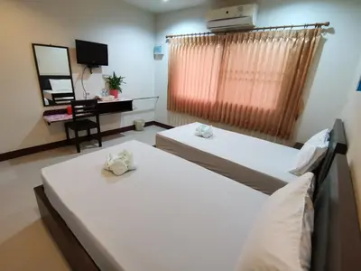 two beds in a room with a desk and a window at Nestvilla Khok-kloi Phang-nga in Ban Nai