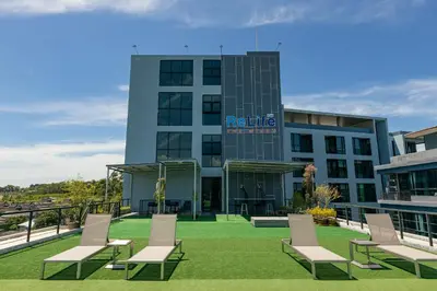 a building with chairs on the lawn in front of it at Relife Windy by Holy Cow, studio with stunning country view in Nai Harn Beach