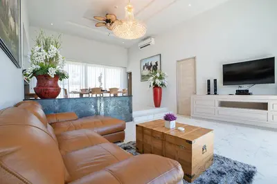 a living room with a couch and a tv at Gold Chariot Pool Villa, Phuket - SHA Plus Certified in Bang Tao Beach