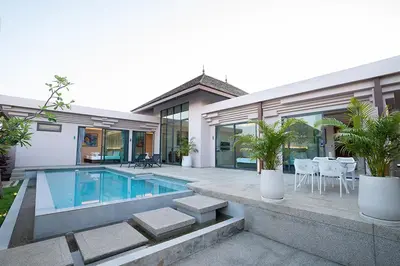 a house with a swimming pool in front of it at Gold Chariot Pool Villa, Phuket - SHA Plus Certified in Bang Tao Beach