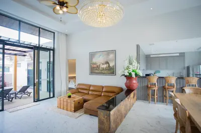 a living room with a couch and a kitchen at Gold Chariot Pool Villa, Phuket - SHA Plus Certified in Bang Tao Beach