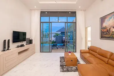 a living room with a couch and a television at Gold Chariot Pool Villa, Phuket - SHA Plus Certified in Bang Tao Beach