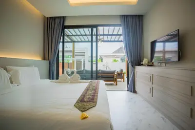 a bedroom with a bed and a tv and a couch at Gold Chariot Pool Villa, Phuket - SHA Plus Certified in Bang Tao Beach