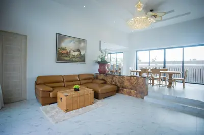 a living room with a brown couch and a table at Gold Chariot Pool Villa, Phuket - SHA Plus Certified in Bang Tao Beach
