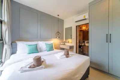 a bedroom with a large white bed with towels on it at 1BDR Apartment near Surin beach #210 in Surin Beach