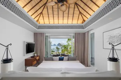 a bedroom with a large bed and a living room at Banyan Tree Krabi in Tab Kaek Beach